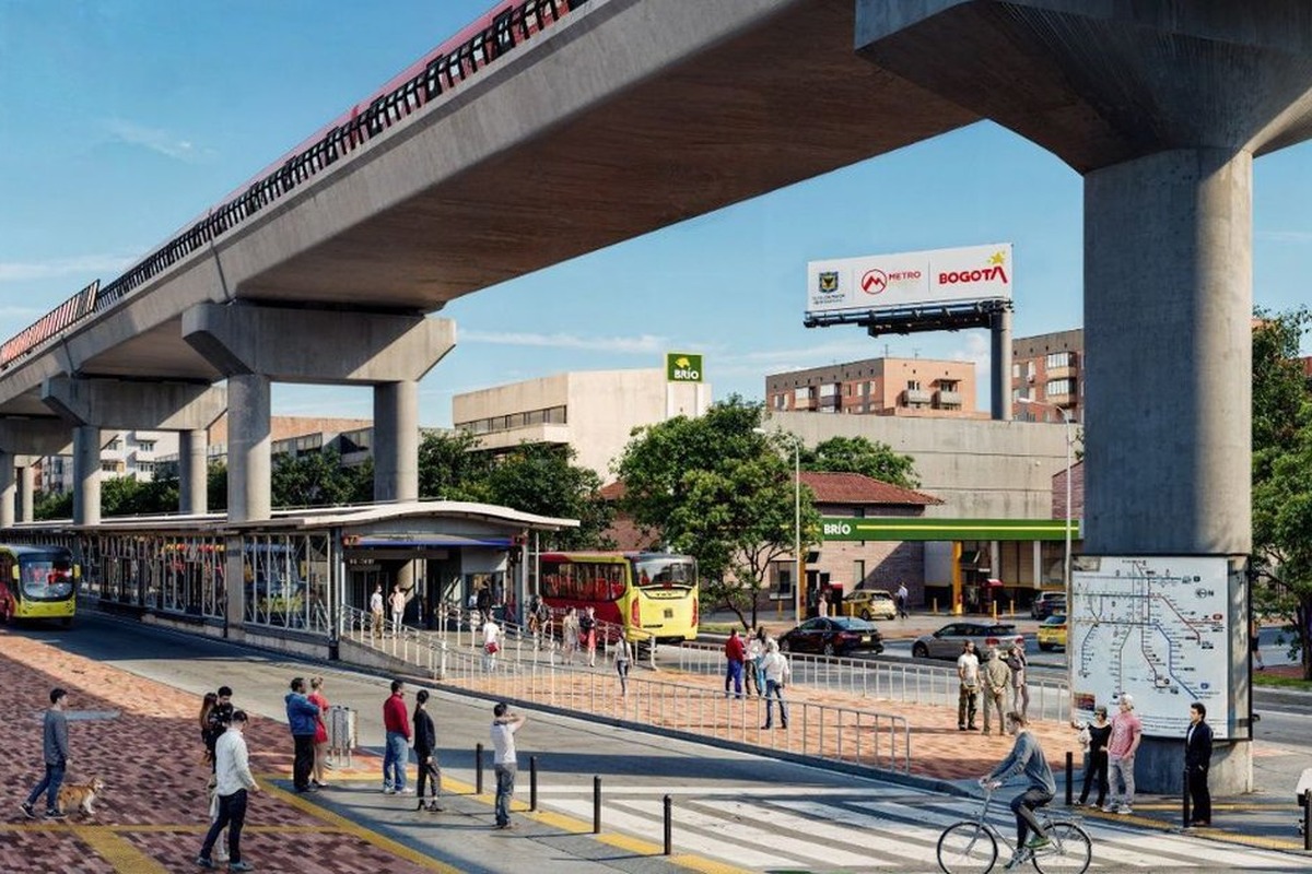Estación urbana con buses rojos y amarillos, plataforma llena de peatones, ciclista cruzando, perro con dueño, elevado de metro, edificios y avisos “BRÍO” y “Bogotá Metro”.